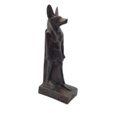 An ancient Egyptian Anubis statue, depicted as a jackalope with a dark bronze finish, standing on a rectangular base with hieroglyphic details, set against a plain white background.