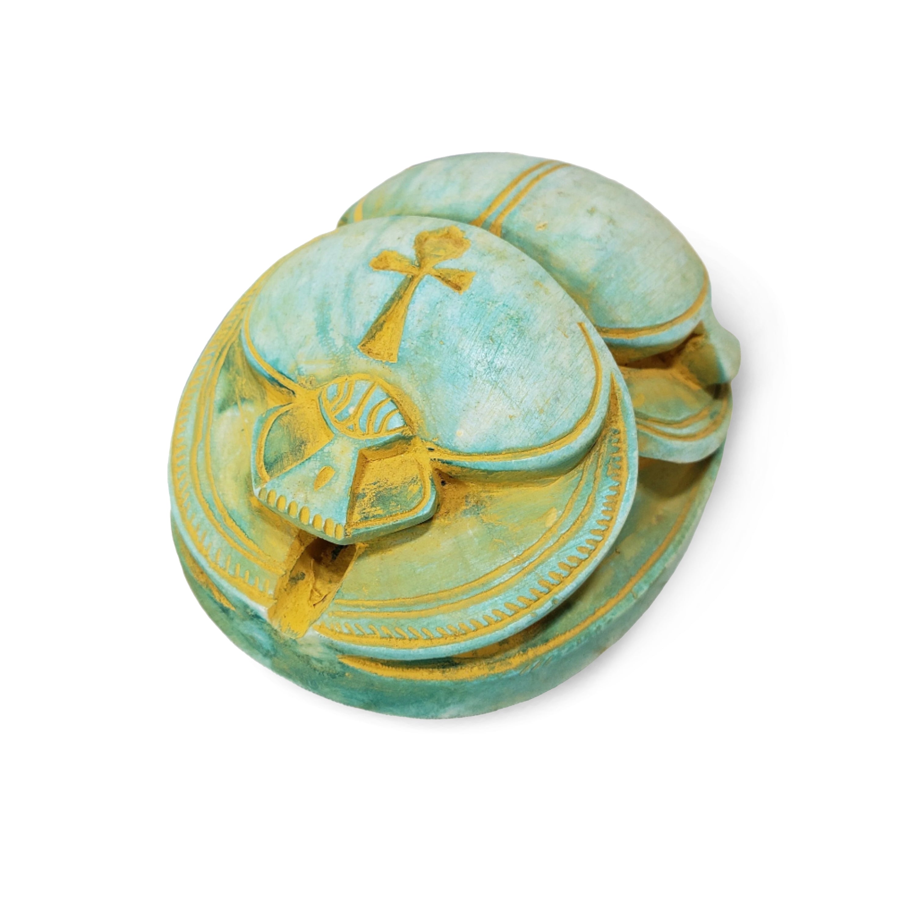 Decorative turquoise and gold scarab object with intricate designs on a white background
