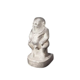 A hand-carved stone statue of the Egyptian God Bes, depicted as a dwarf with large ears, a long-haired and bearded figure, holding a rattle.