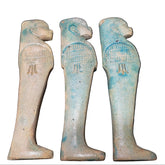 A set of four blue ceramic canopic figures representing the four sons of Horus, each with a different facial expression and detailing.