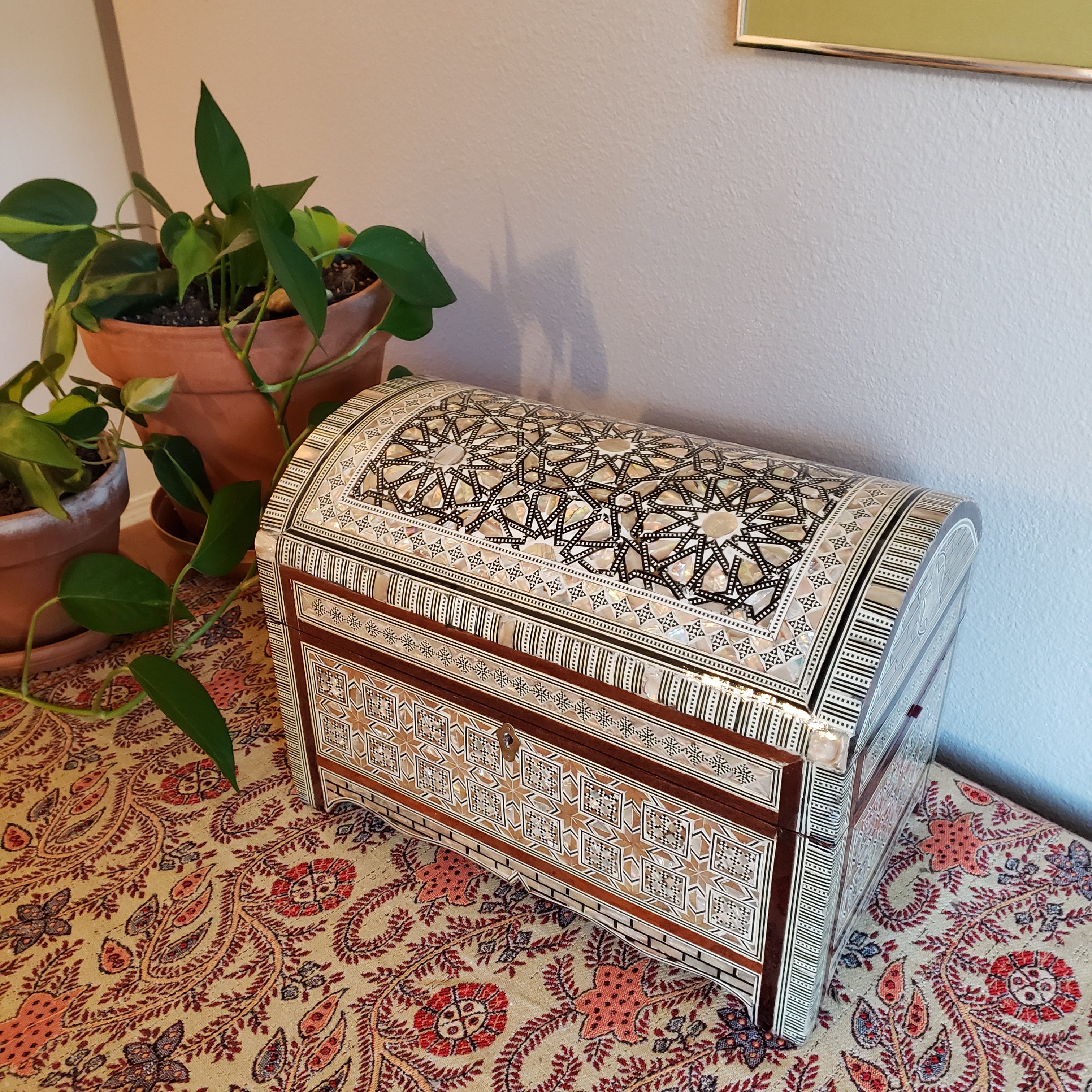 Decorative box with intricate patterns on a patterned fabric background