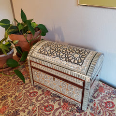 Decorative box with intricate patterns on a patterned fabric background