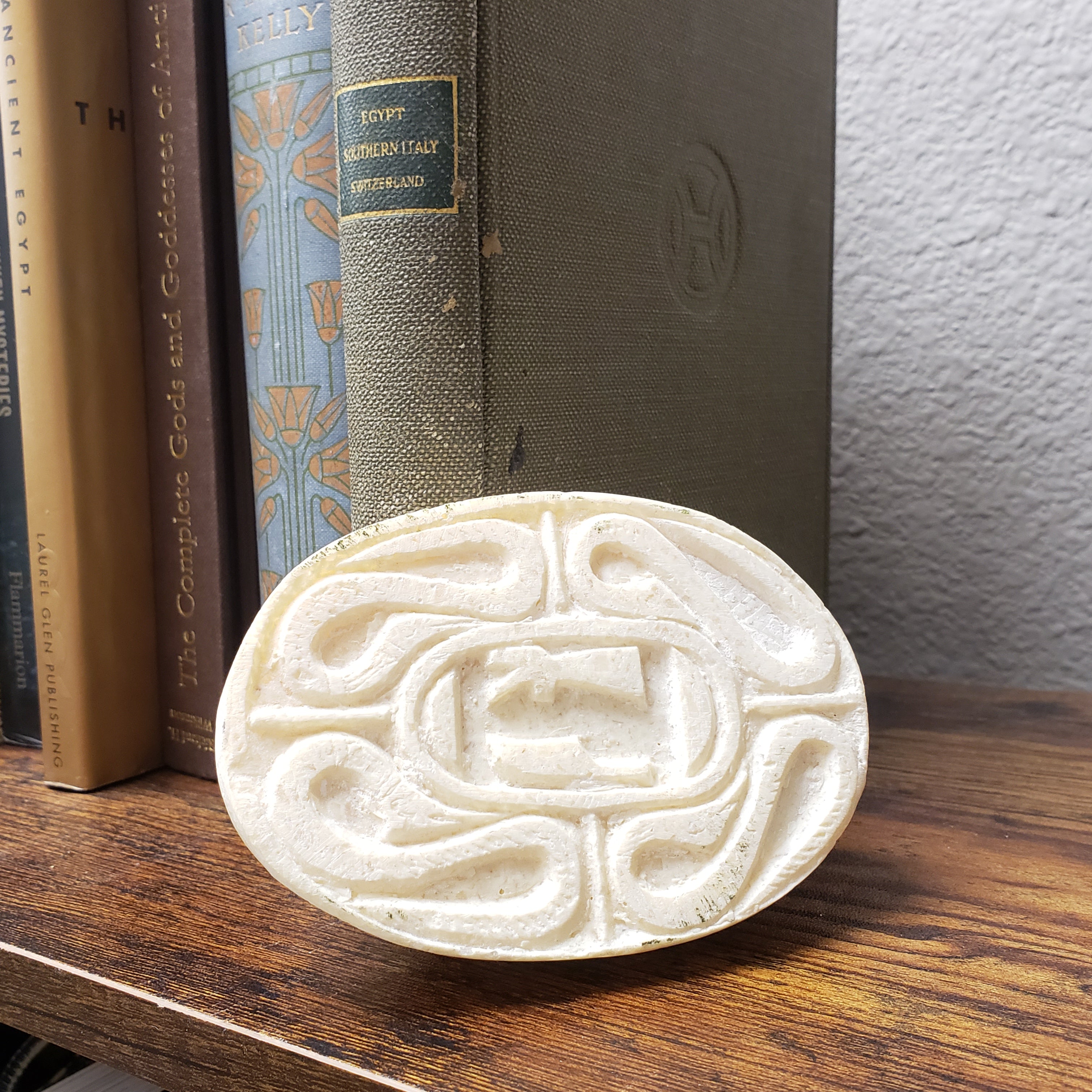 Decorative scarab with intricate design on a stack of books