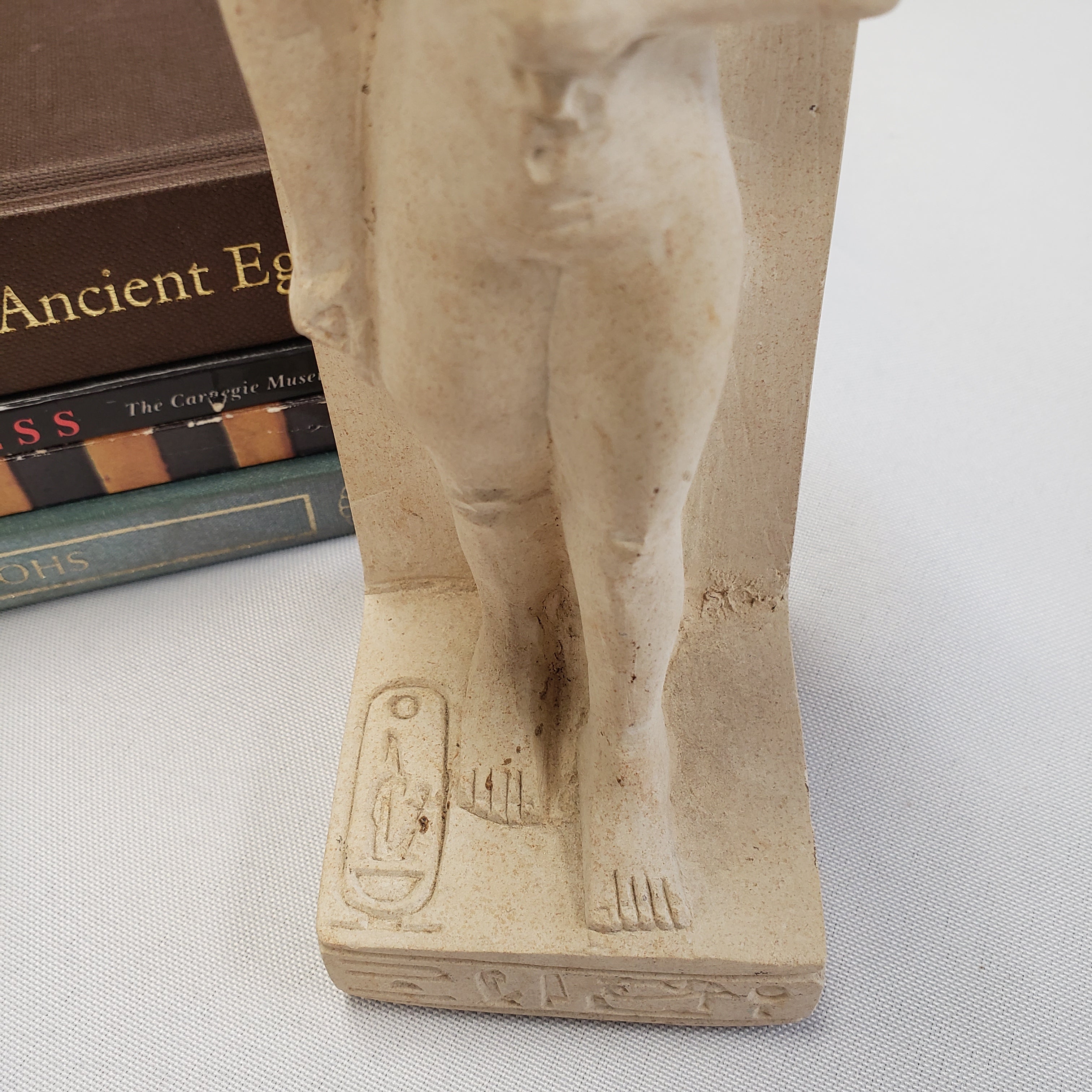 Small stone statue of a figure on a white background