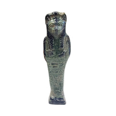 Decorative Egyptian Sehkmet figure on top, leaning against books in a room with plants and wooden paneling.