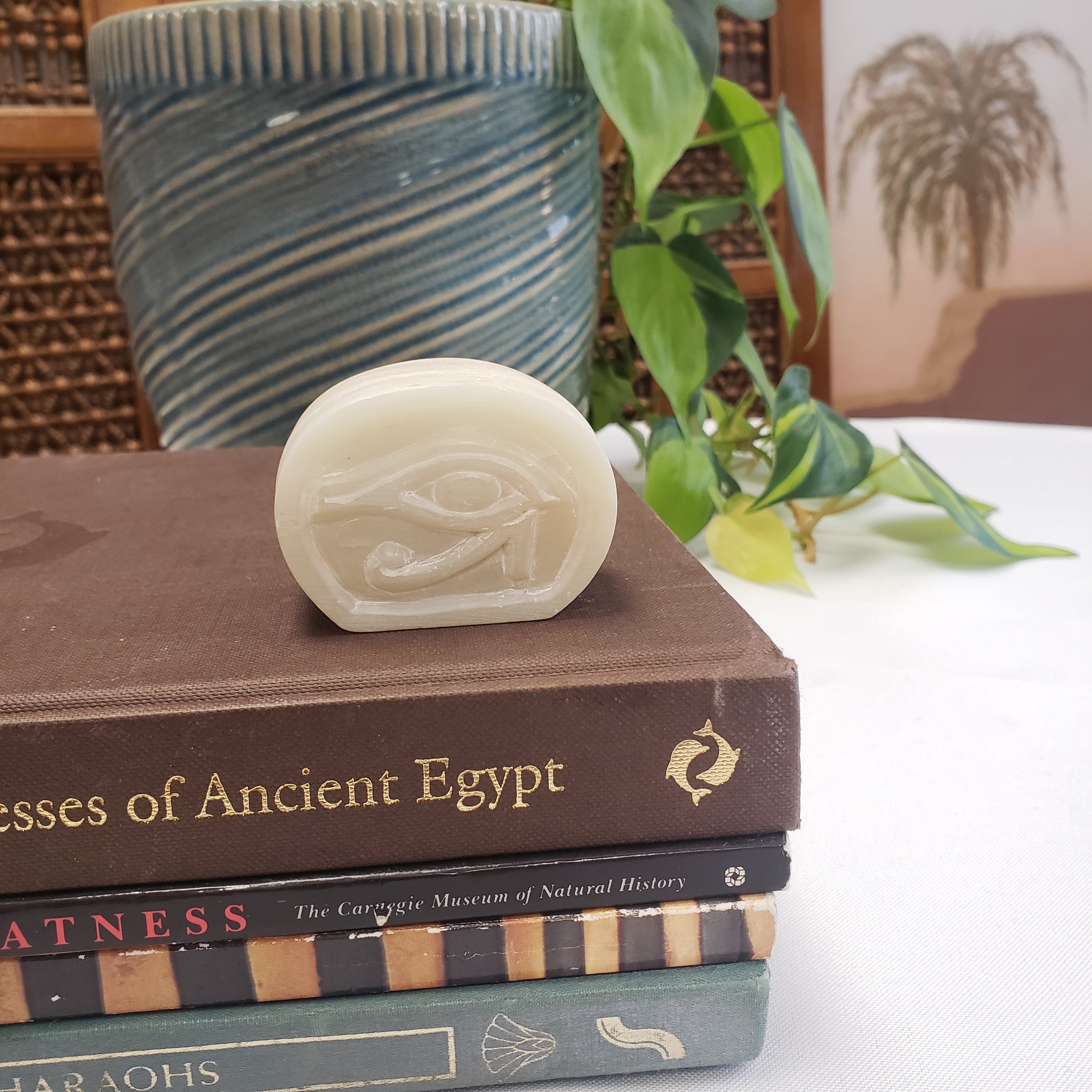 White soapstone box with an eye symbol on top of books