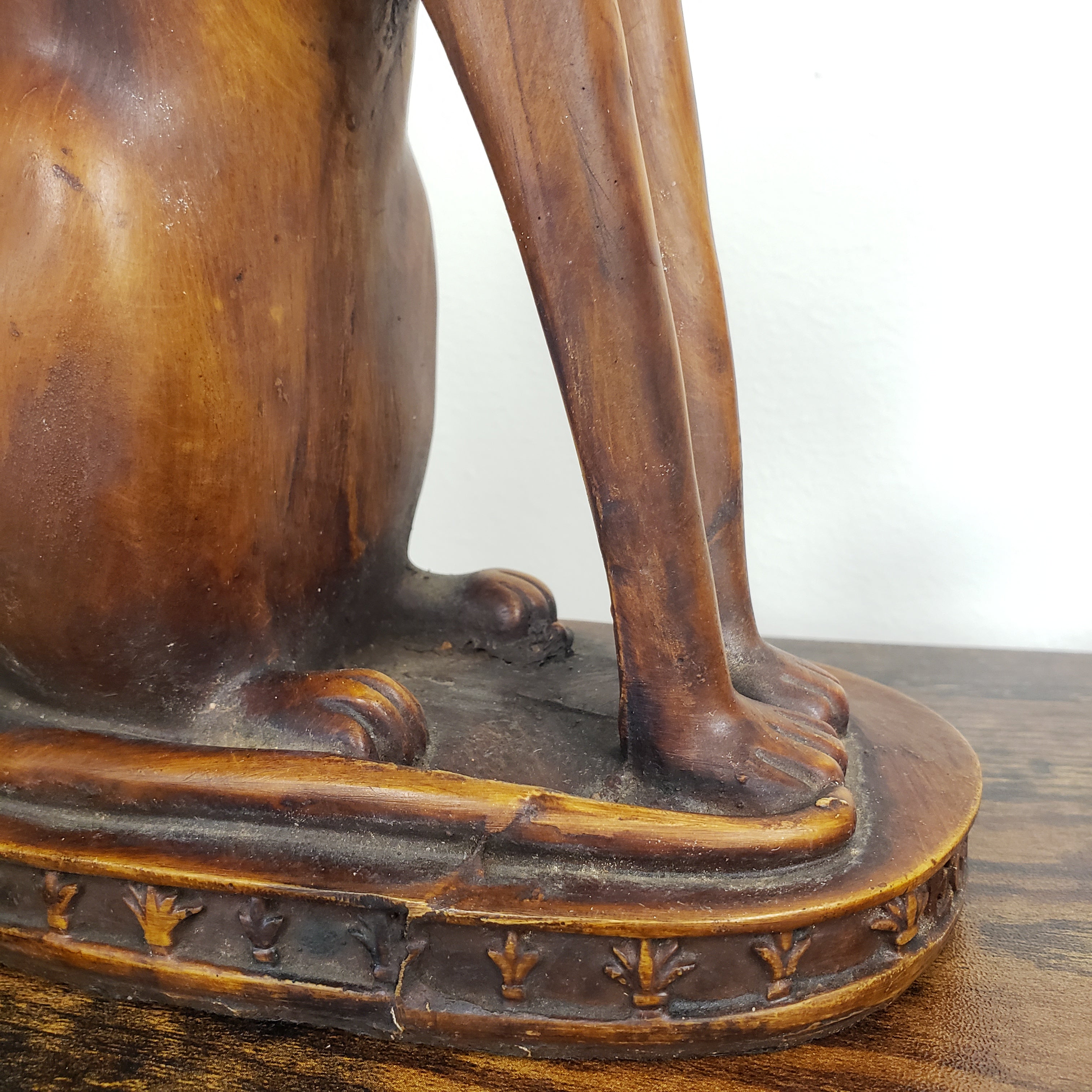 Close-up of an ornate cat statue with intricate carvings on a white background