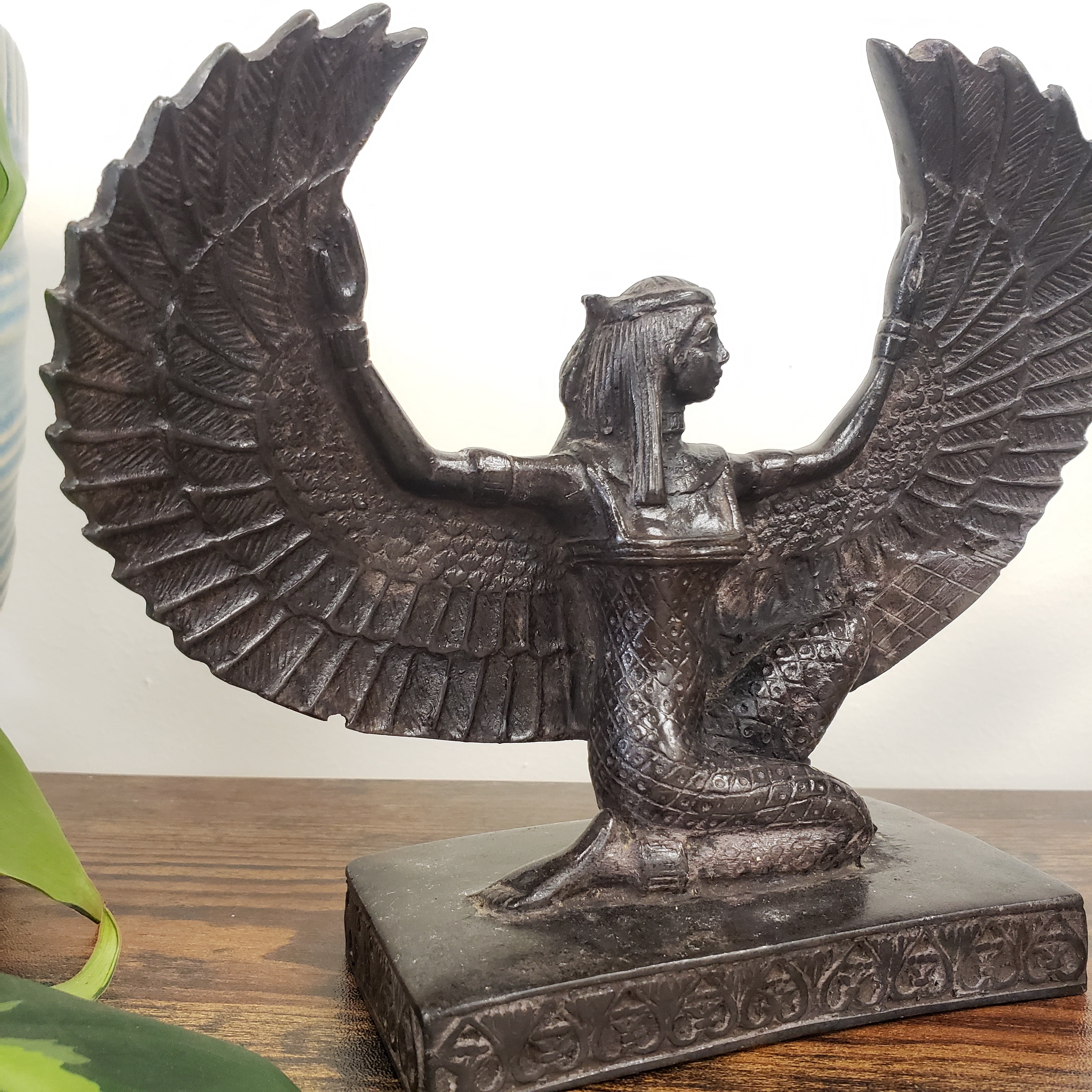 Decorative Egyptian Isis statue on a wooden surface