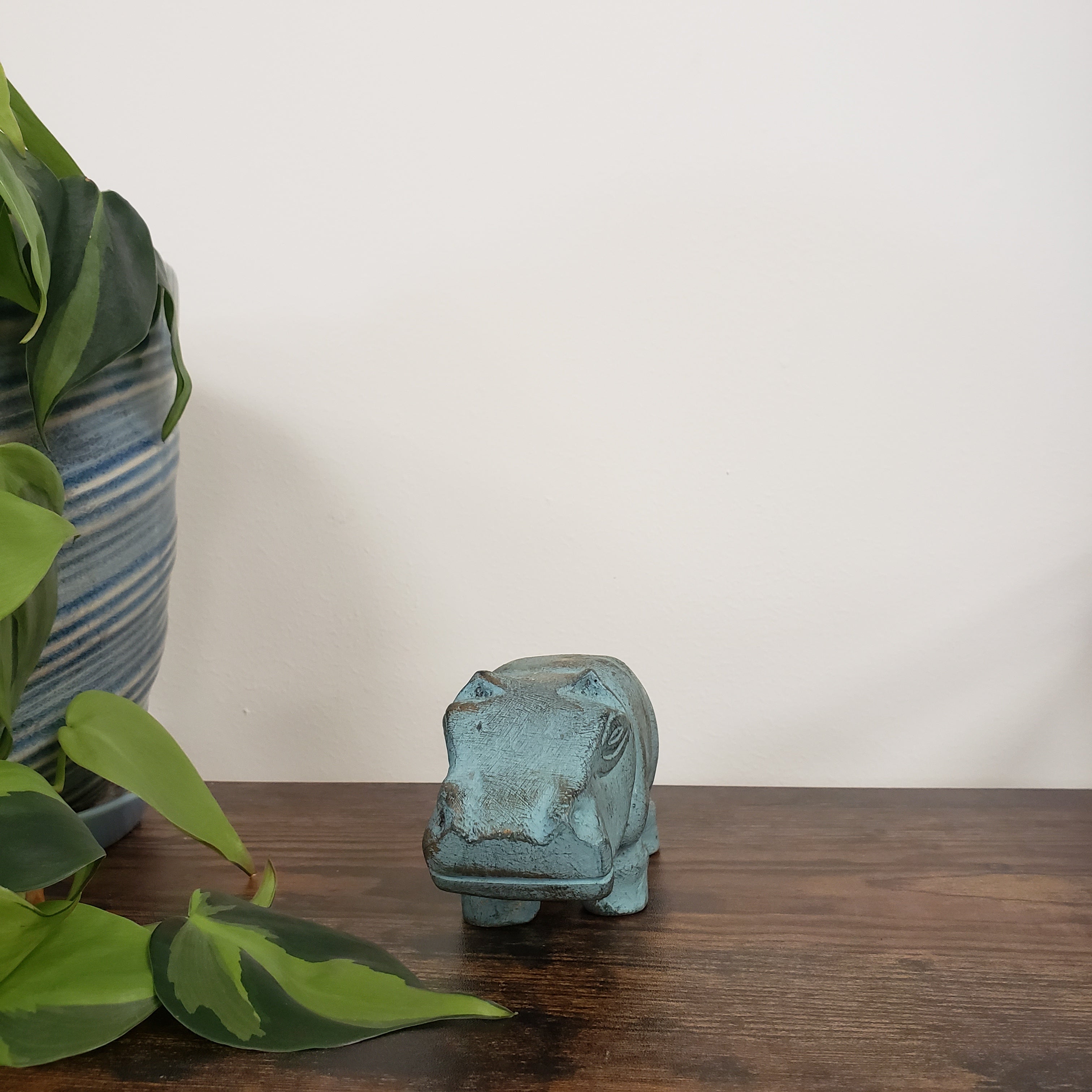 Decorative hippo statue with plants in the foreground