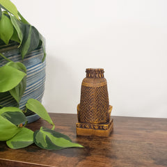 Decorative Egyptian Queen Mutnejmet Statue on a wooden surface with plants in the foreground