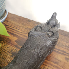 Decorative Anubis object with intricate carvings on a wooden surface