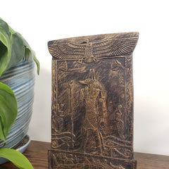 Decorative Anubis plaque with carvings on a white background