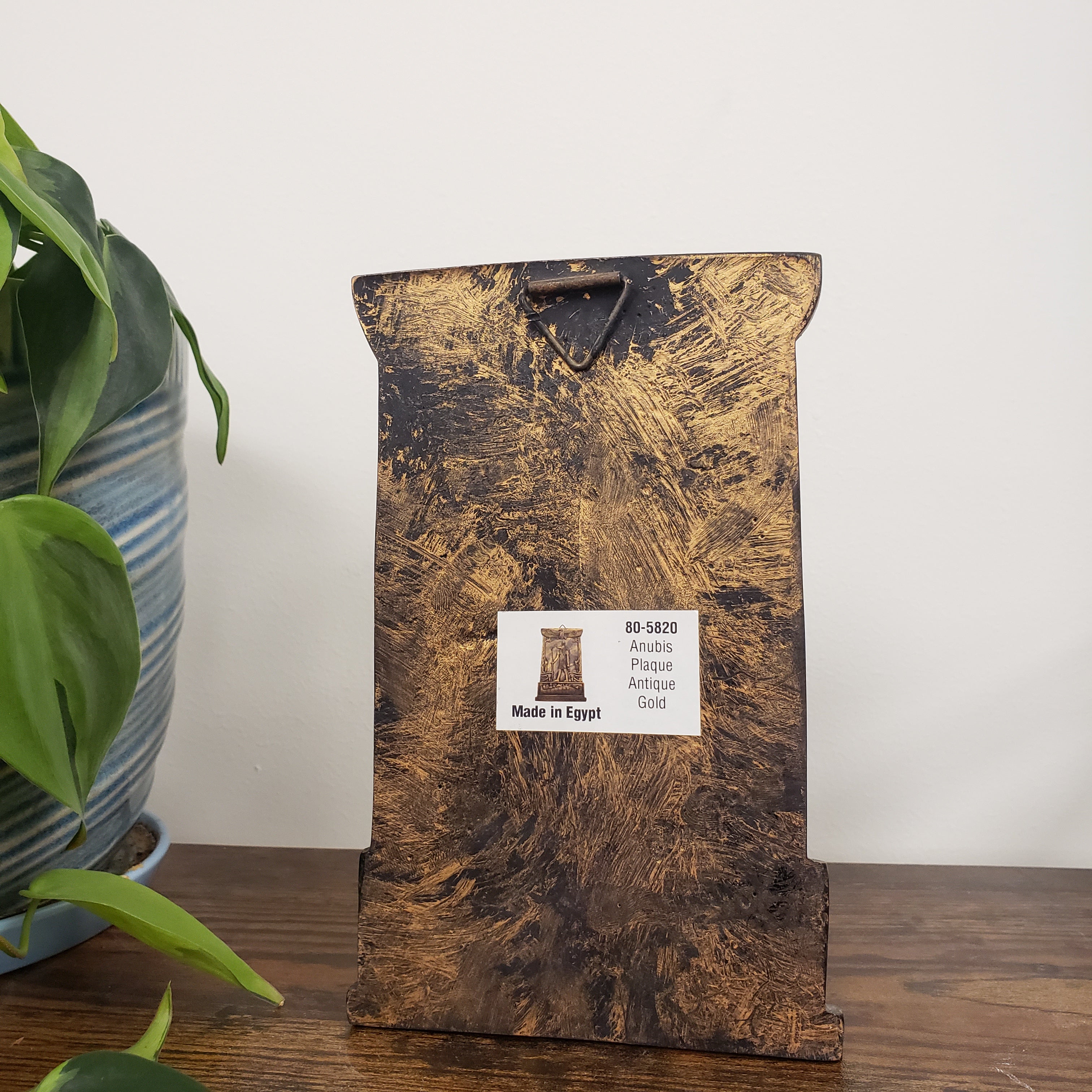 Anubis plaque with a textured surface and a label on a white background