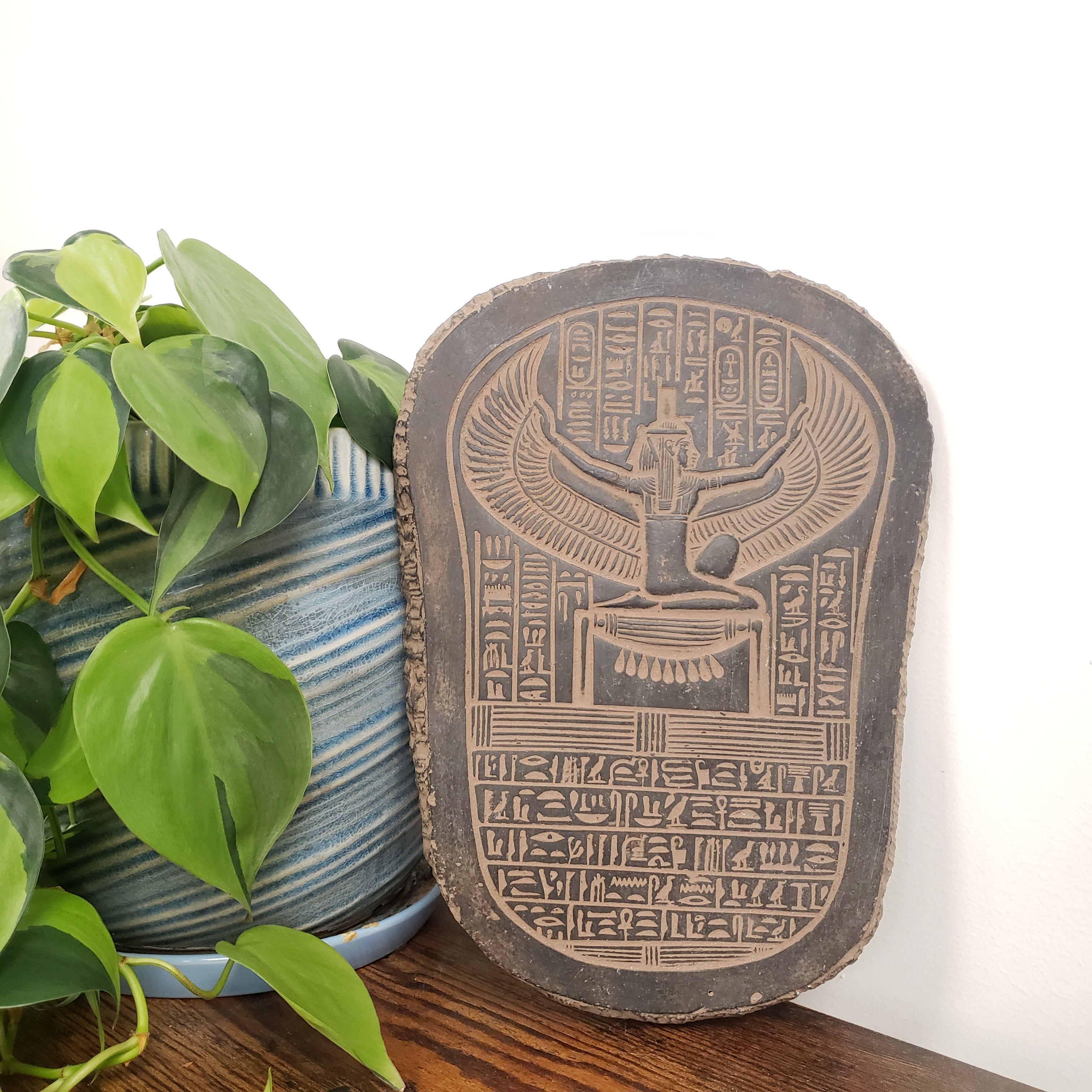 Decorative stone with hieroglyphics on a plant pot