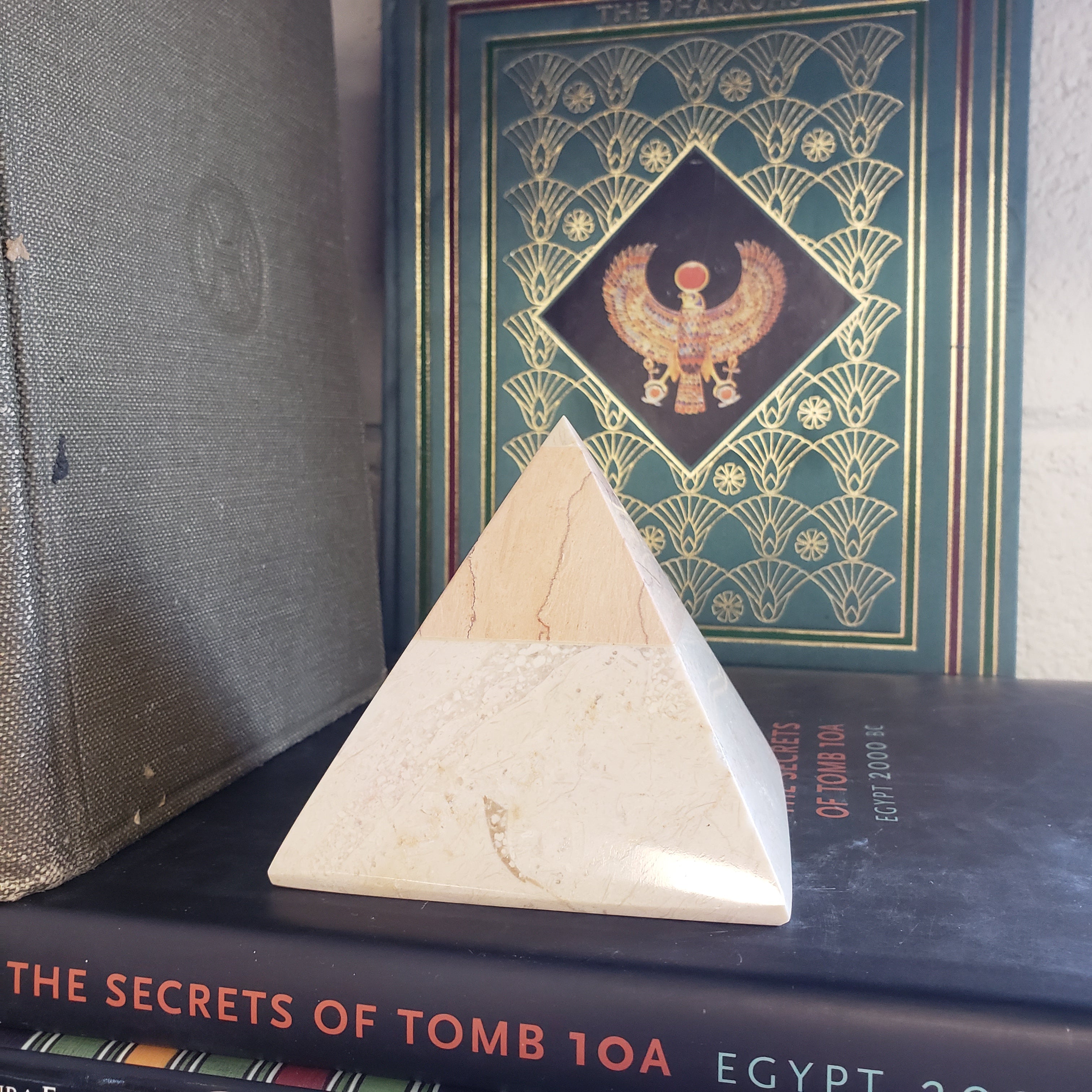 Wooden pyramid-shaped object on a book with decorative cover