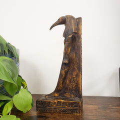 Egyptian god Thoth sculpture with decorative carvings on a white background