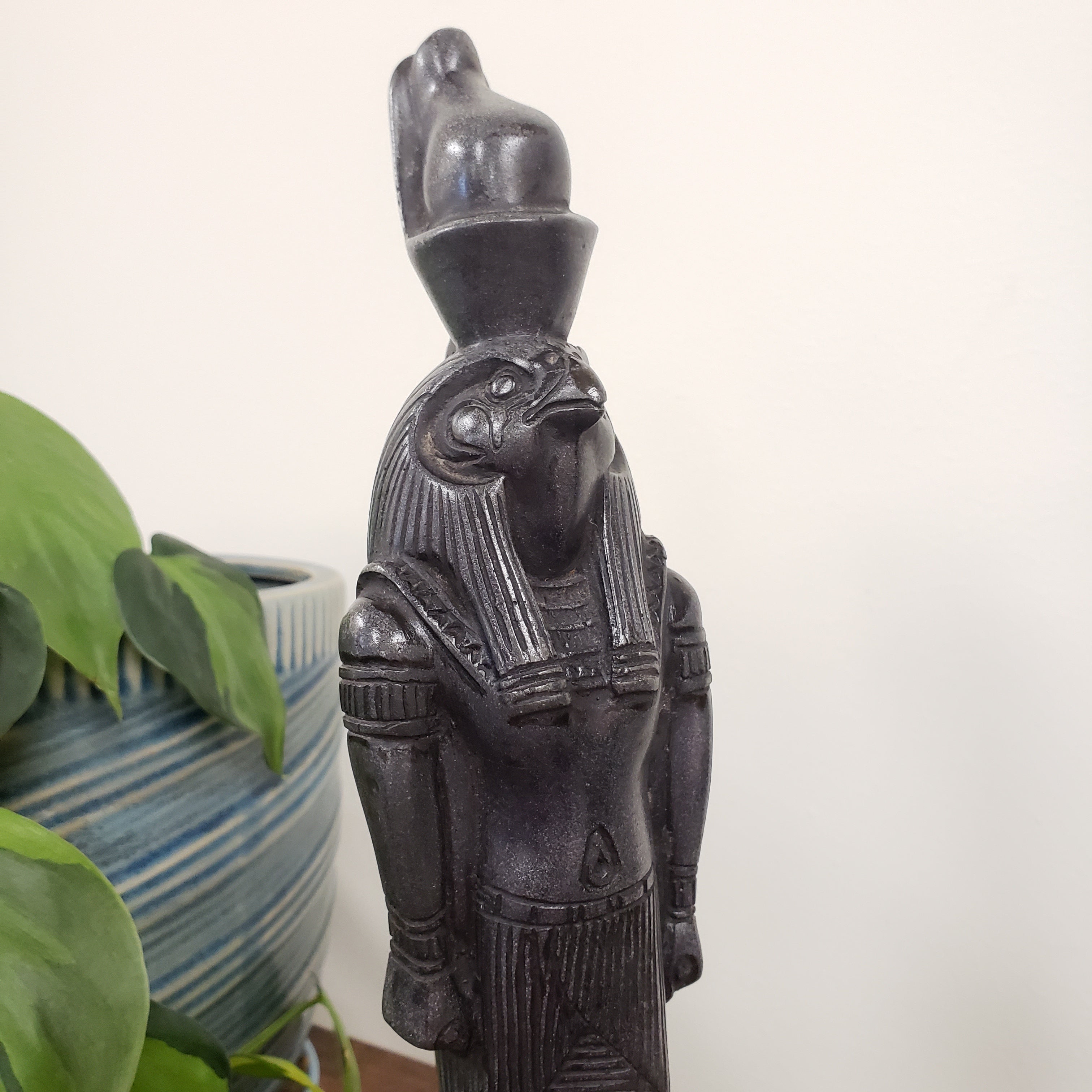 Decorative black Egyptian god Ra statue with intricate details on a white background