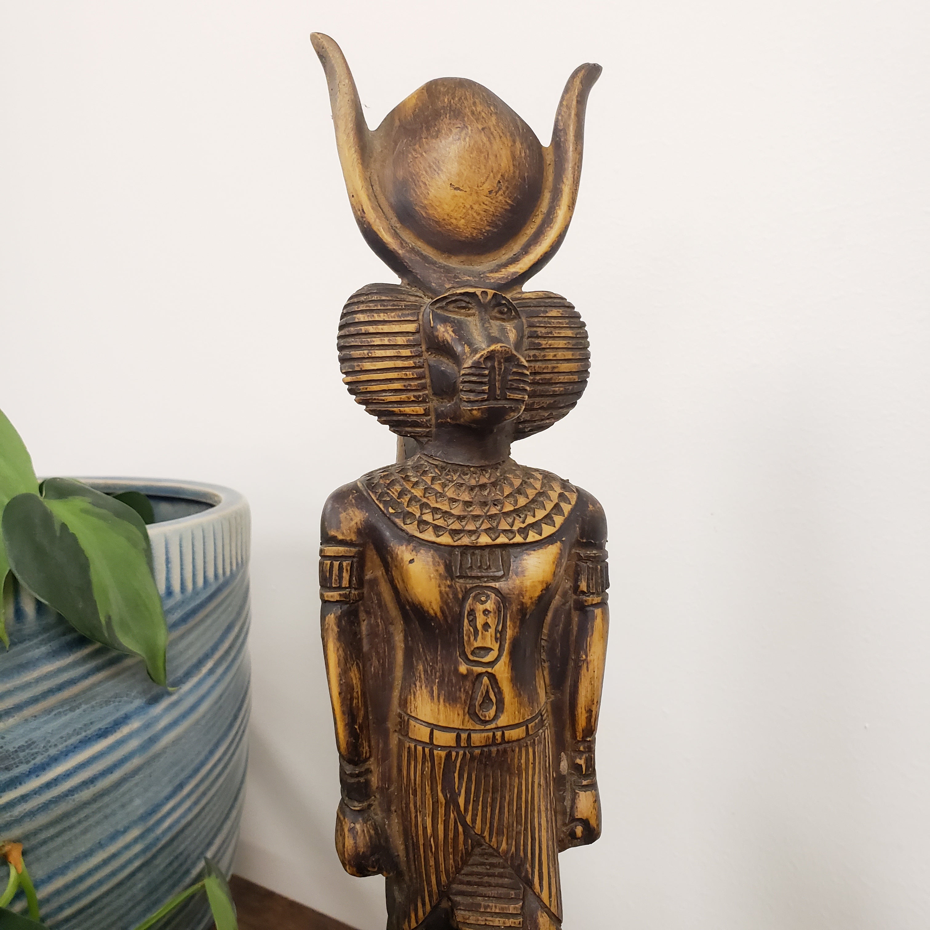 Statue of a deity with a headdress on a white background