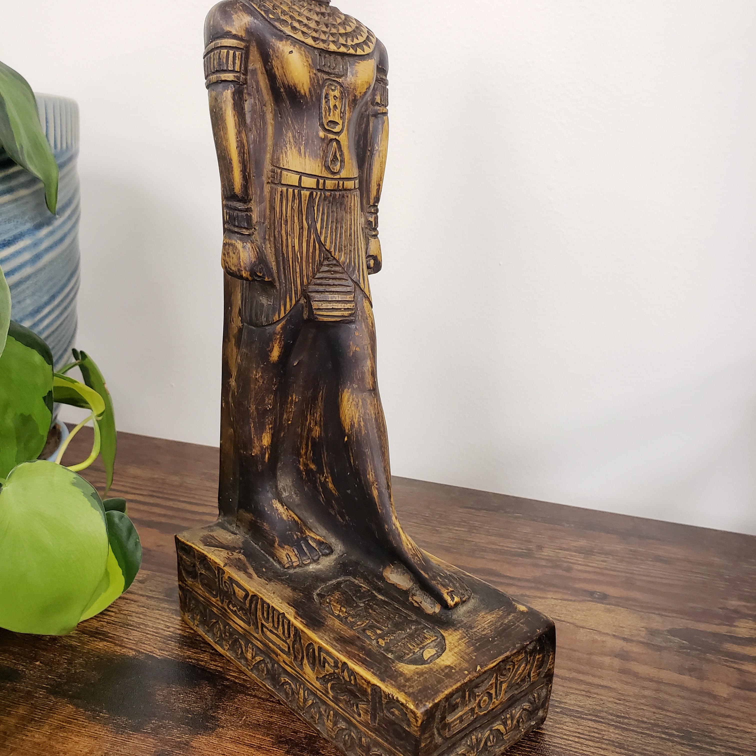 statue of the Egyptian god Babi  decorative carvings on a wooden surface.