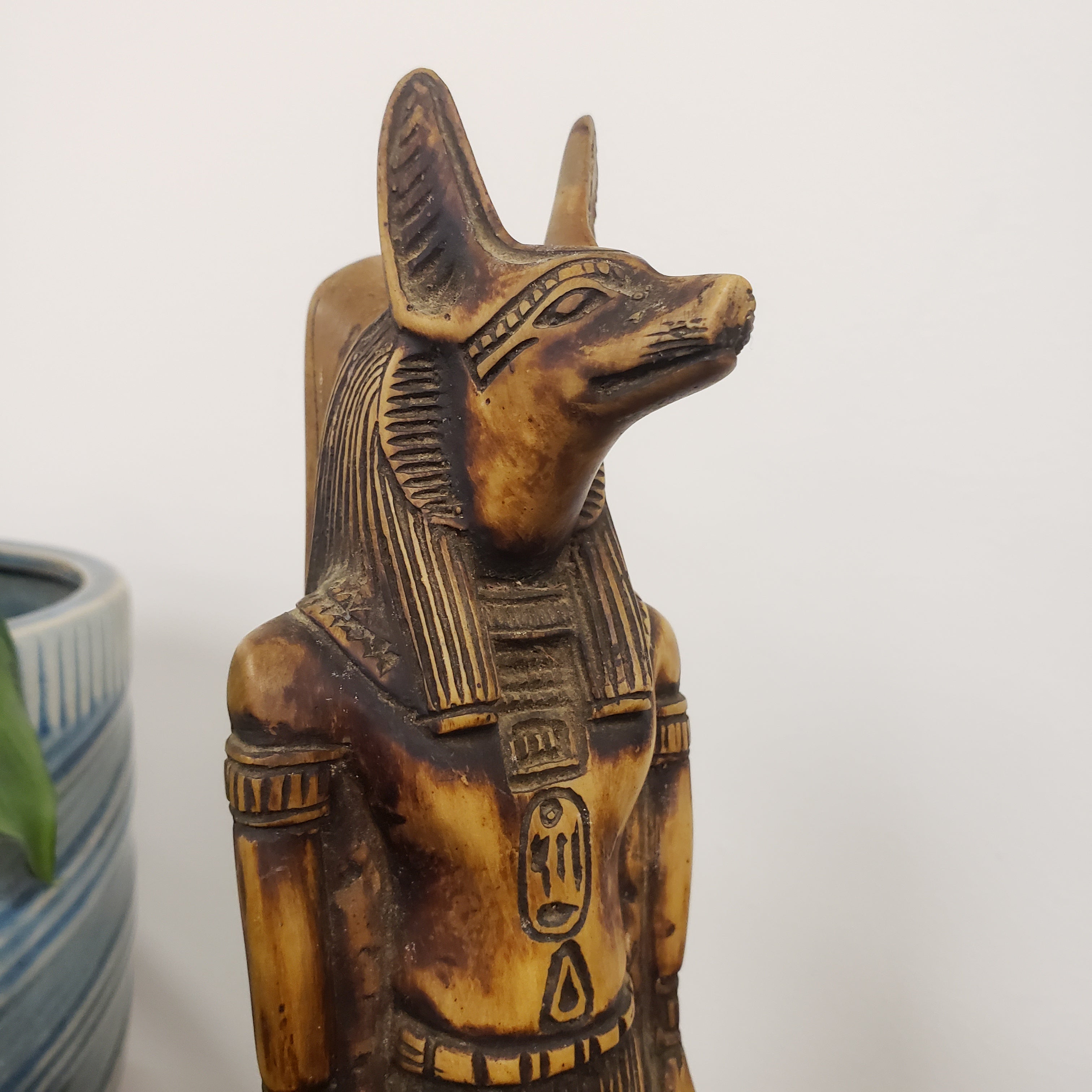 Decorative statue of the Egyptian god Anubis with intricate designs on a white background