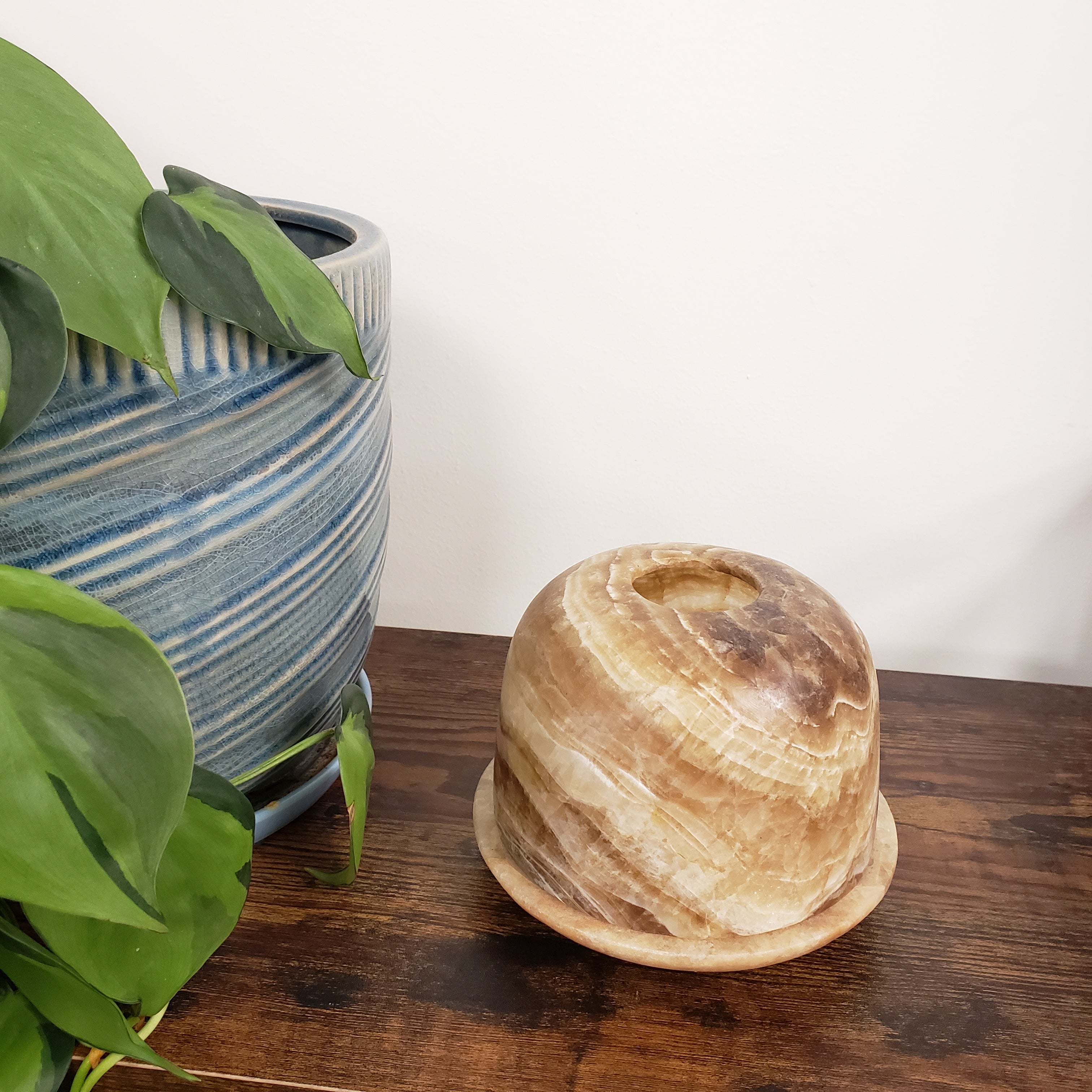 alabaster votive holder on a wooden surface with a white background