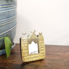 Decorative mirror with Arabic text on a wooden surface.