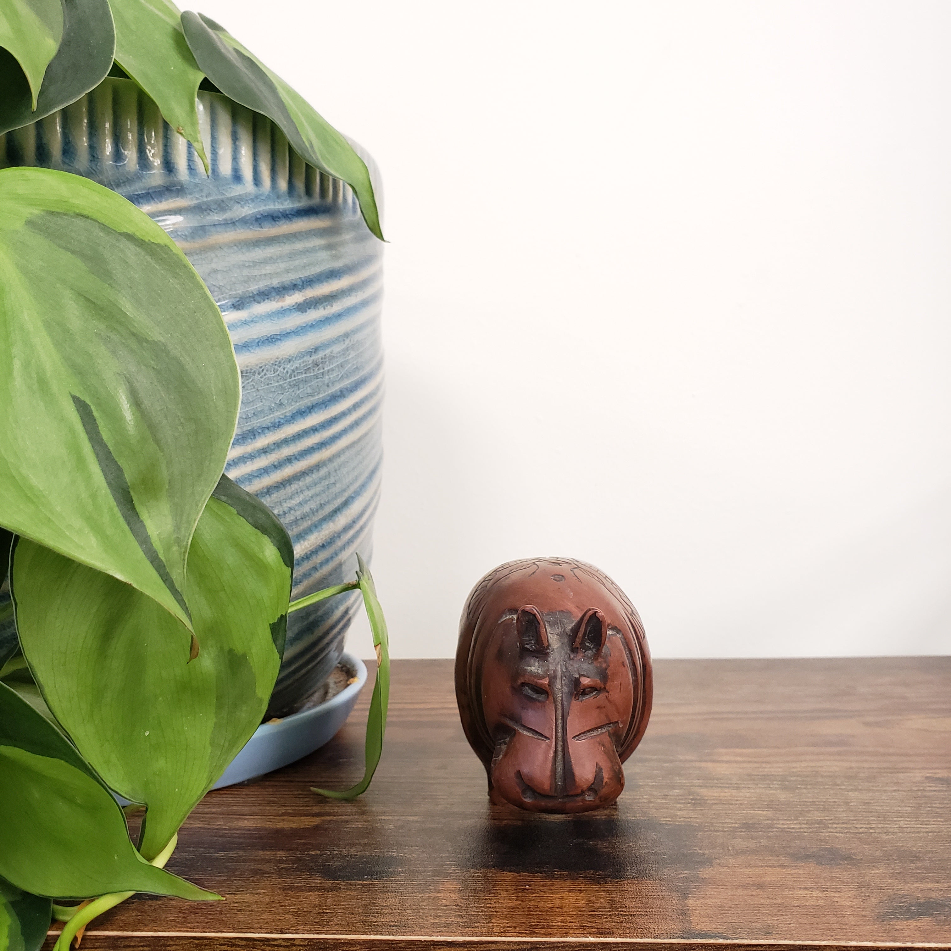 Close-up of a hippo statue with green leaves in the foreground