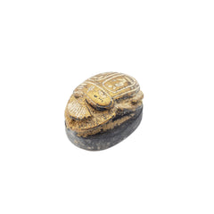 Decorative gold scarab statue with intricate carvings on a white background