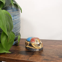 Decorative Egyptian scarab statue on a wooden door with plants in the foreground