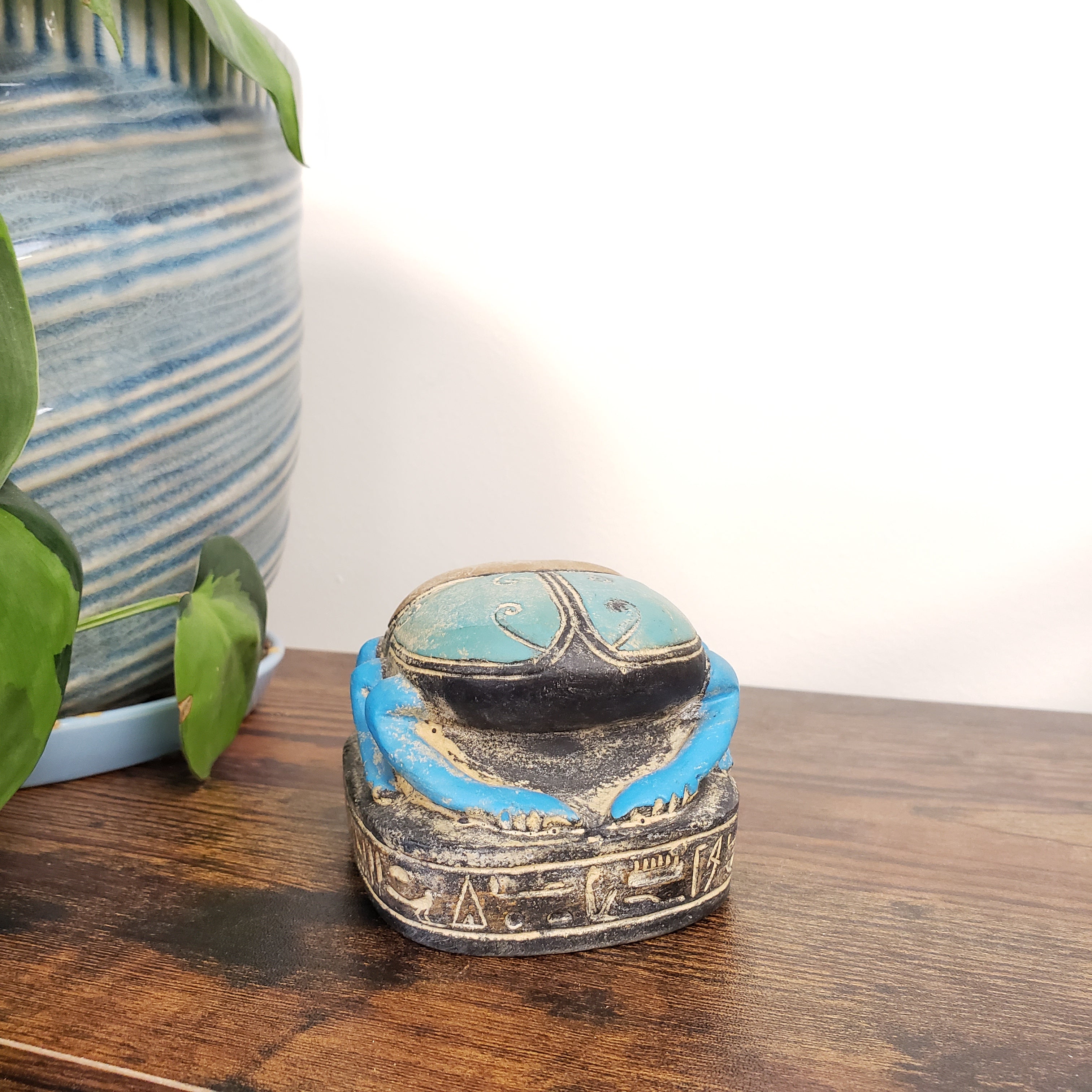 Decorative Egyptian scarab statue on a wooden surface