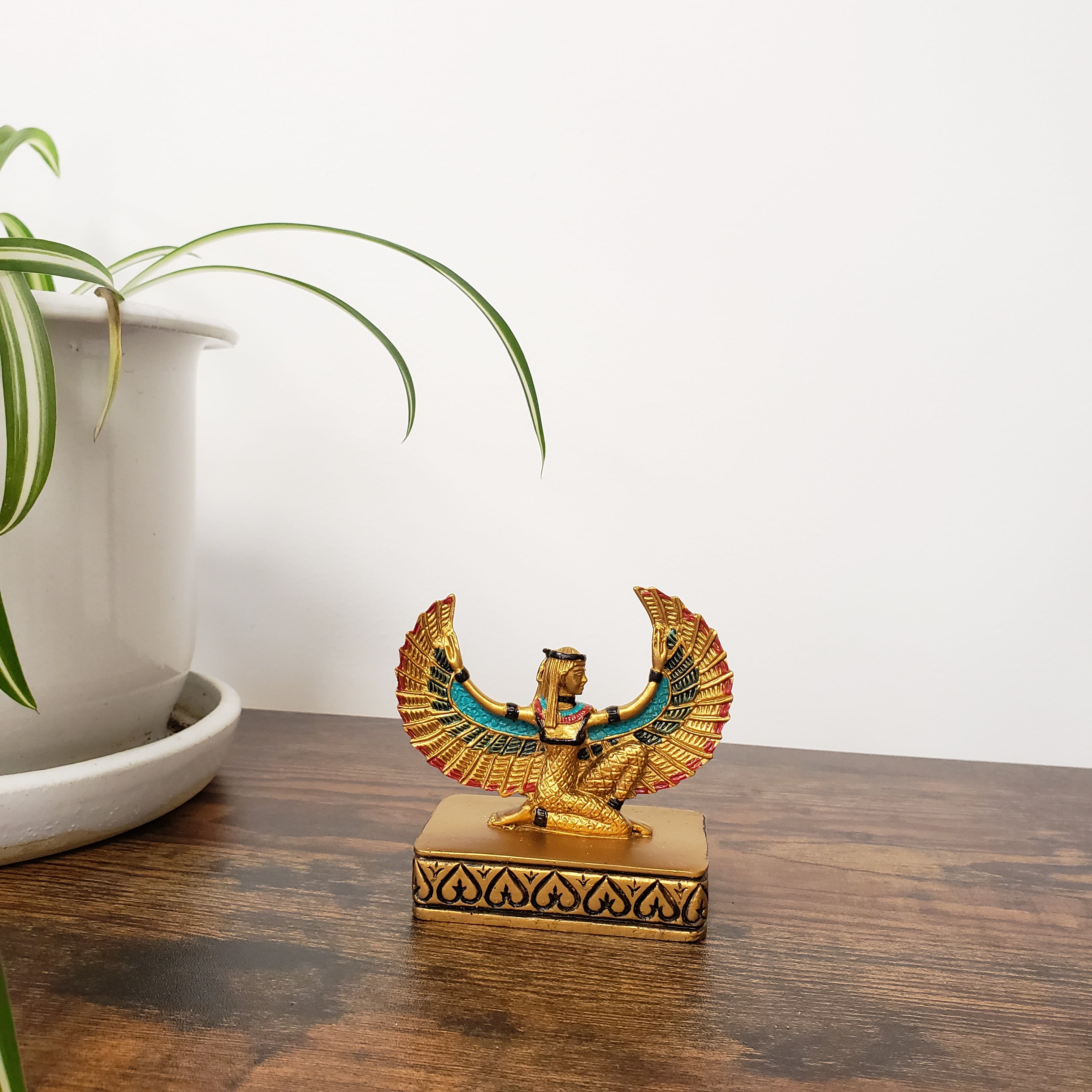 Decorative statue with Egyptian-style design on a wooden surface.