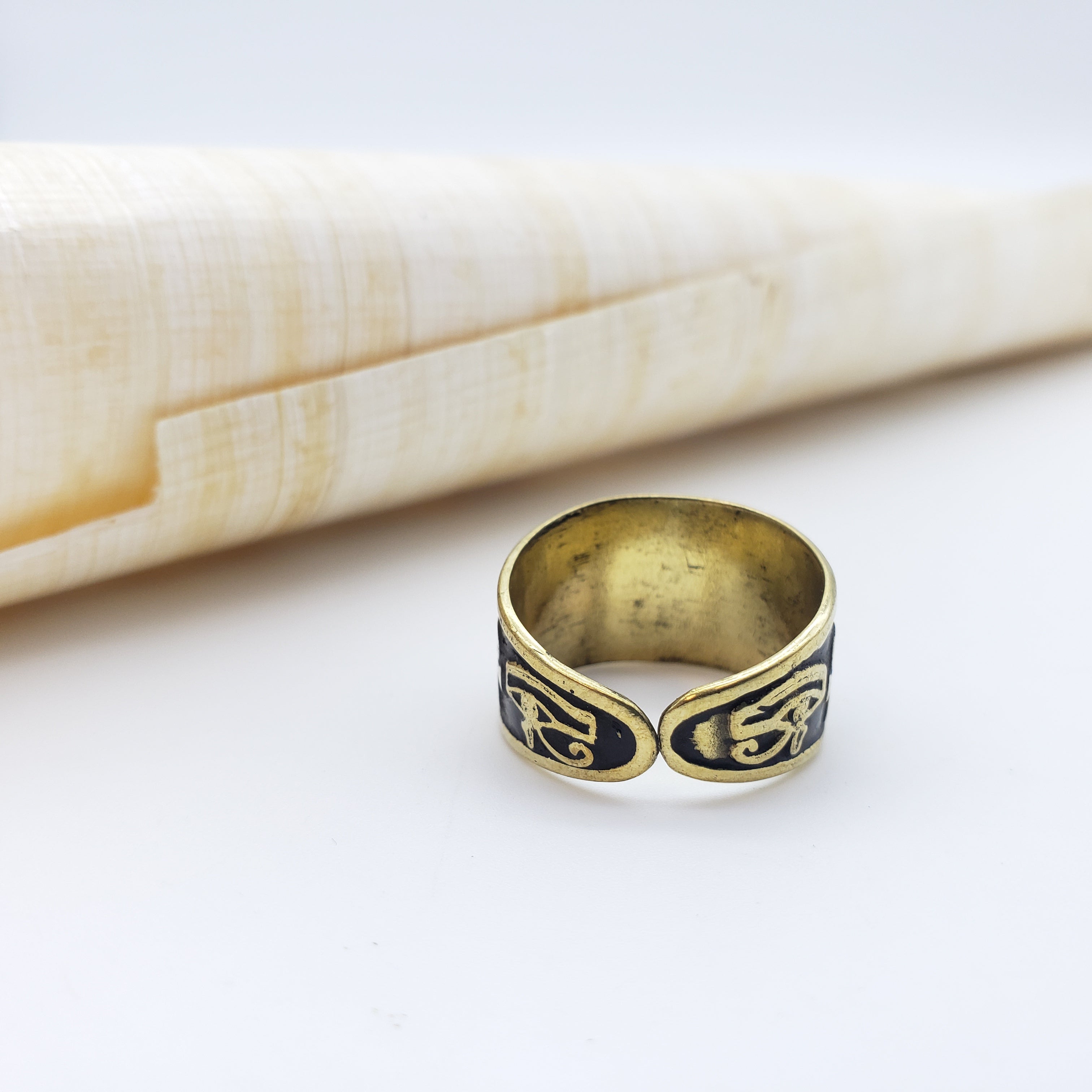 Bronze ring with intricate design on a white surface