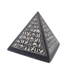 Pyramid-shaped object with hieroglyphic designs on a white background
