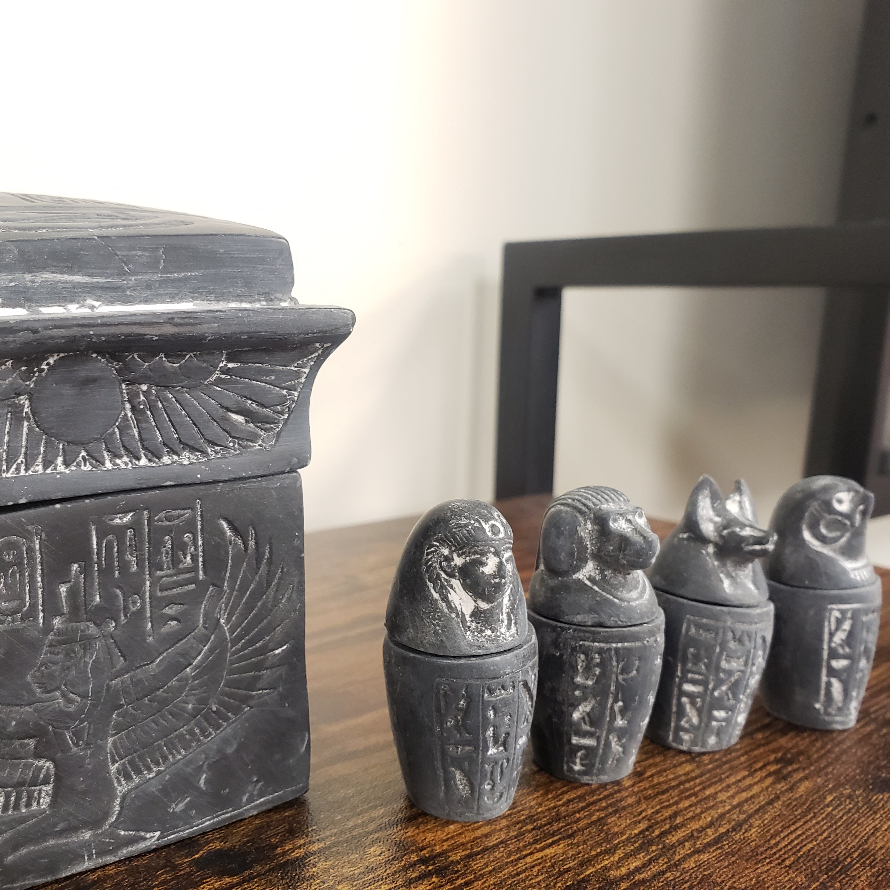 Decorative items with hieroglyphic designs on a wooden surface.