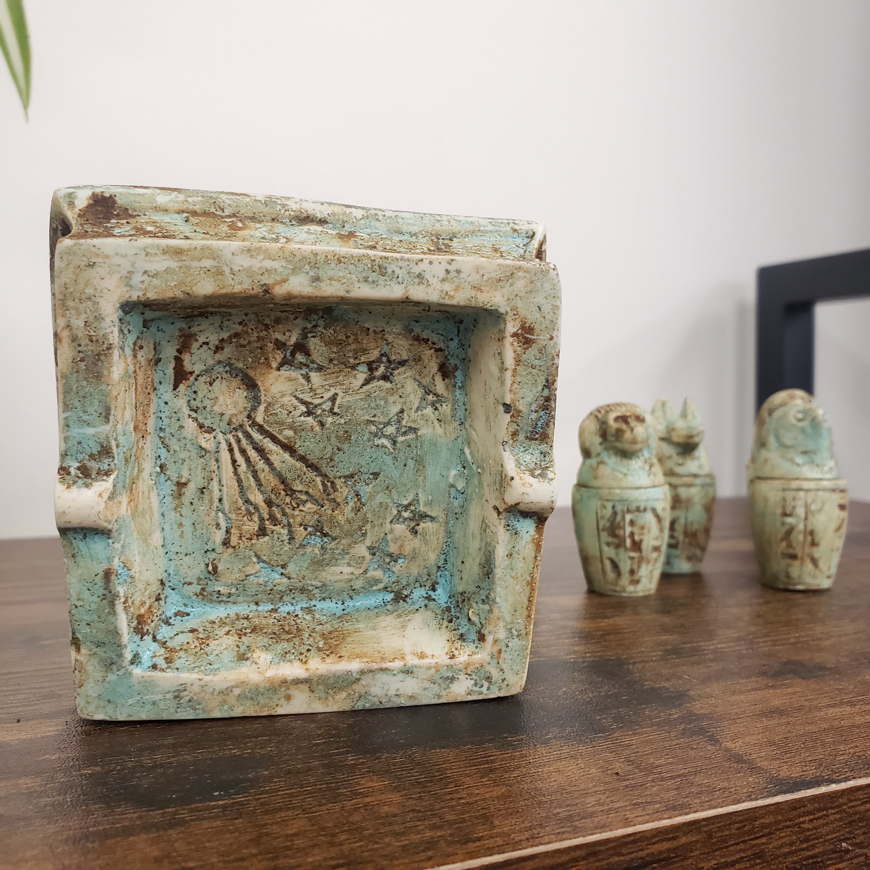 Decorative ceramic piece with intricate design on a wooden surface