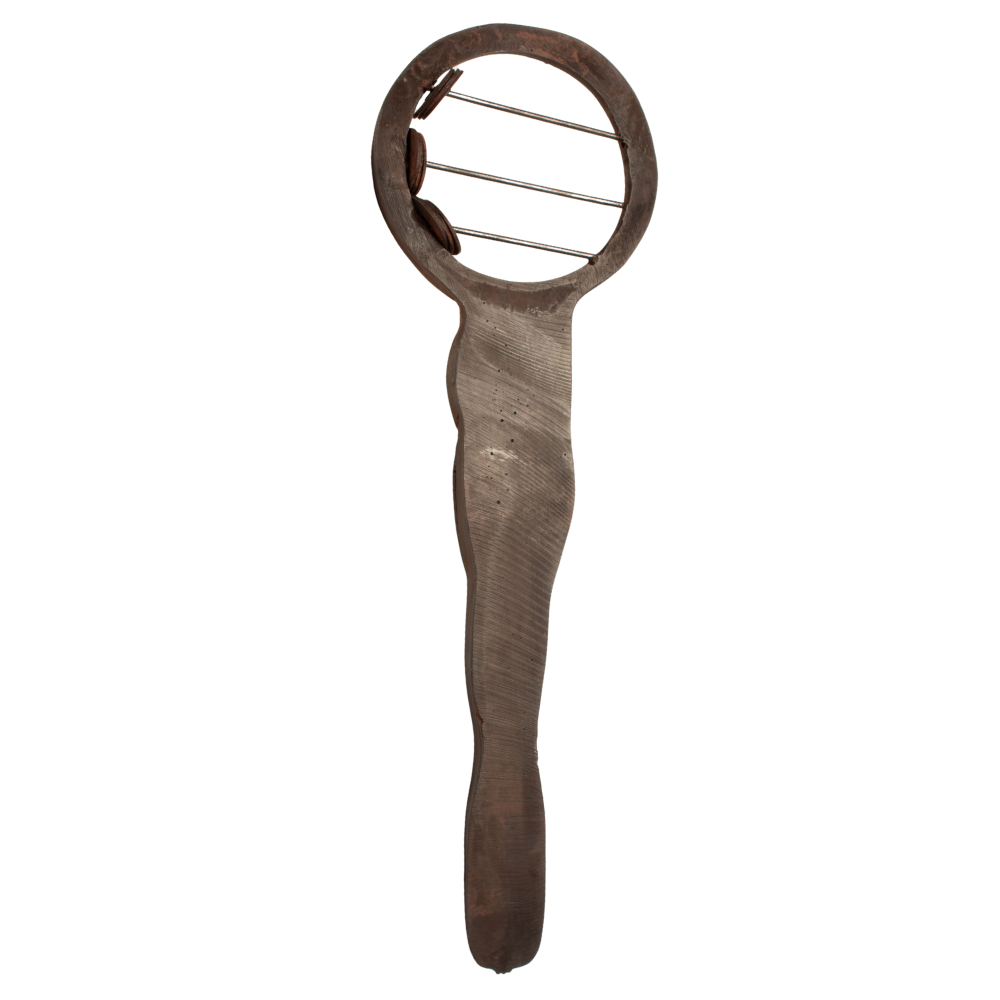 A rustic sistrum with a circular head featuring three metal teeth and a wavy, hand-hewn handle, shown against a plain white background.