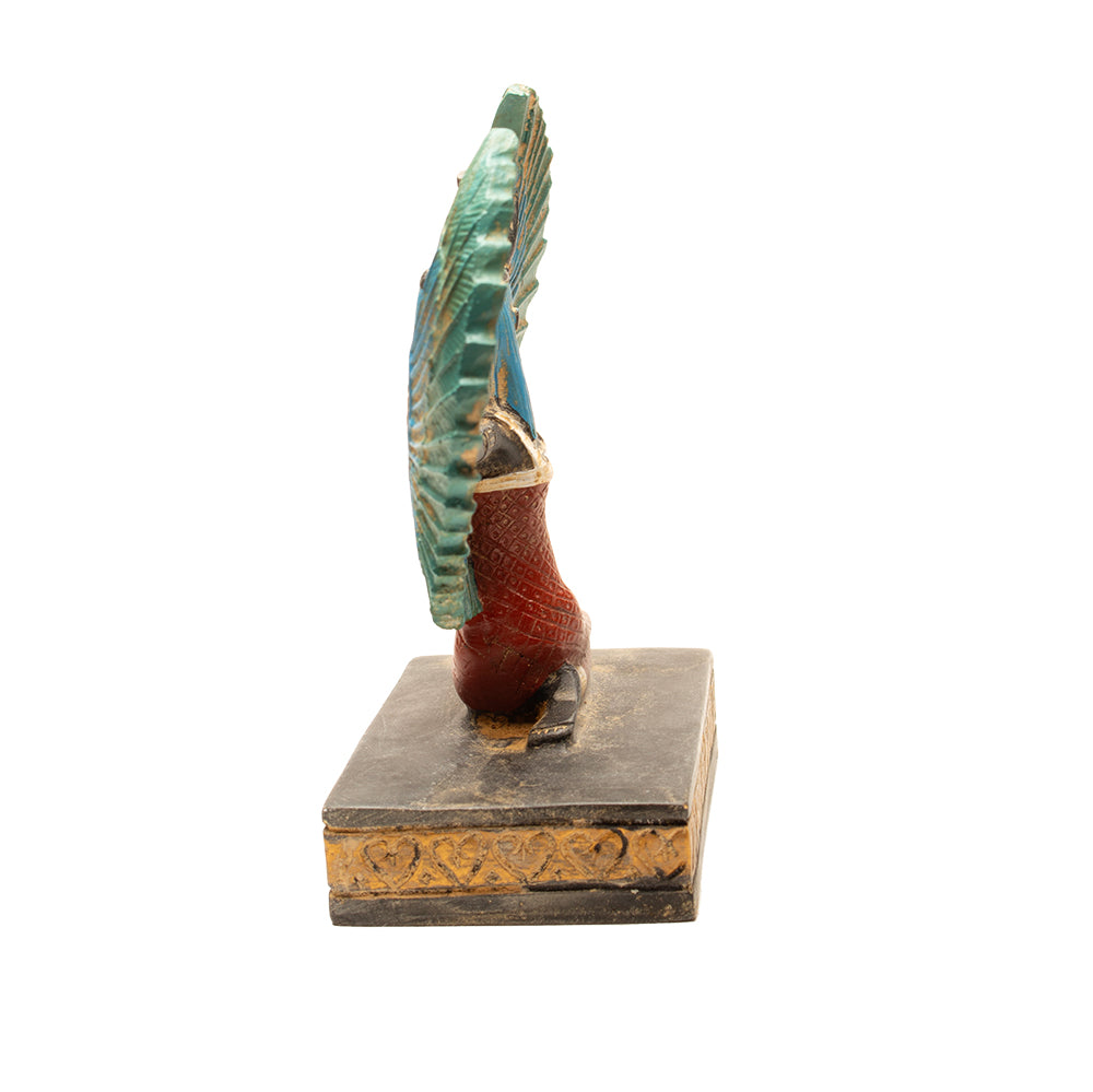 Decorative item with a winged figure on a square base against a white background