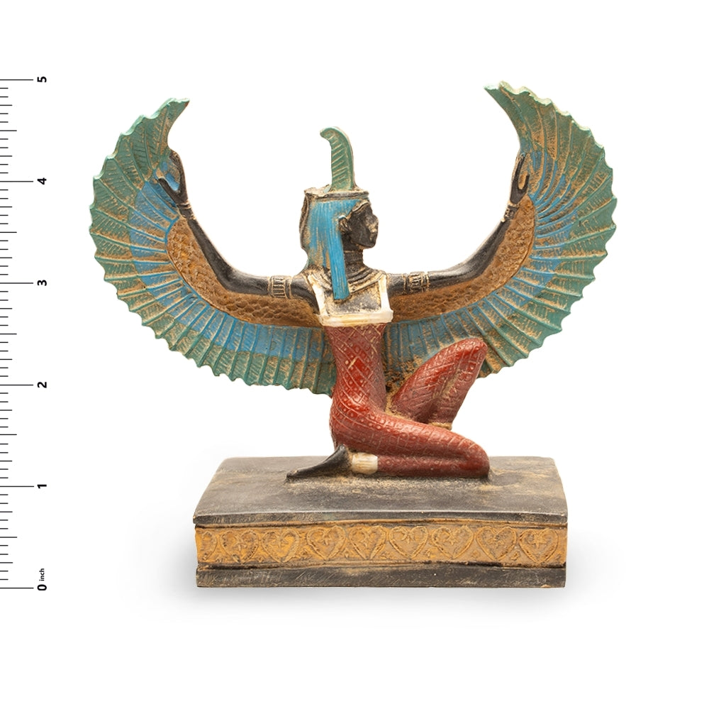 Decorative figure of a winged Egyptian goddess on a white background with a ruler for scale.