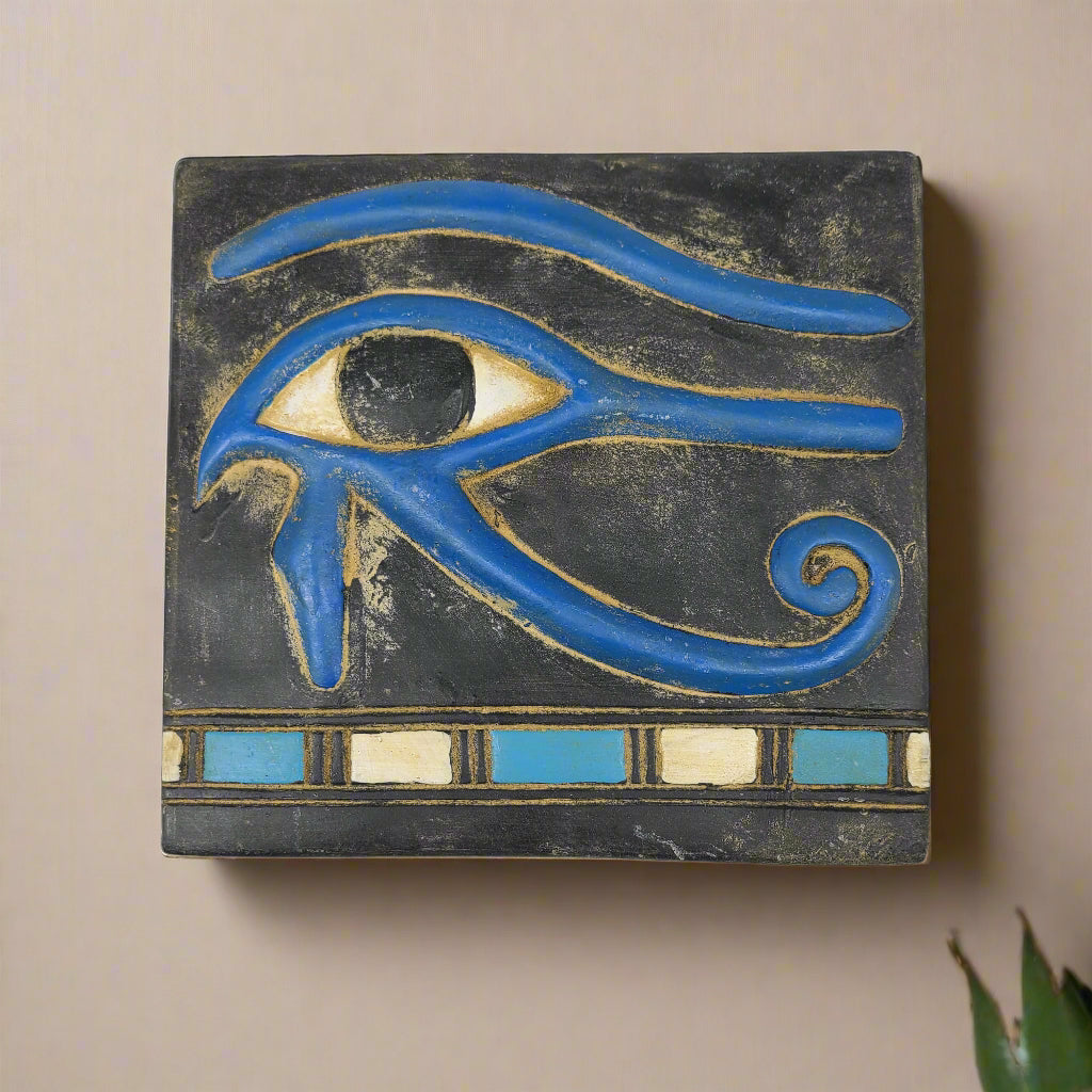 Decorative tile with a blue eye design on a black background
