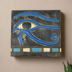 Decorative tile with a blue eye design on a black background