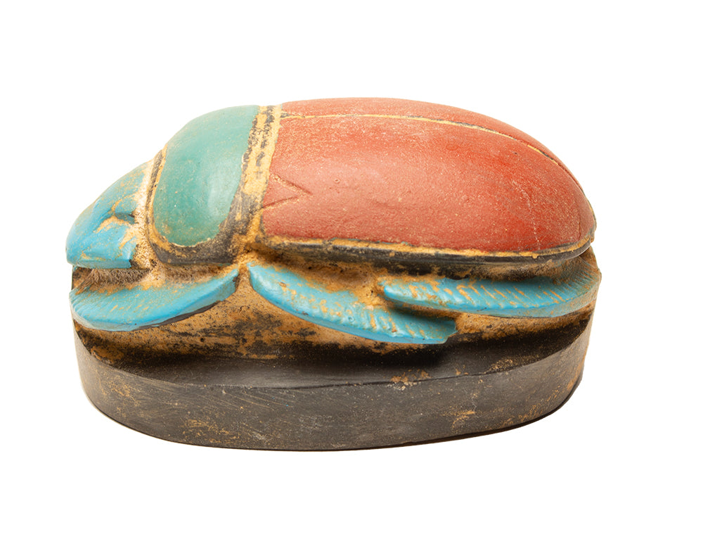 Decorative box shaped like a beetle with colorful paint on a white background