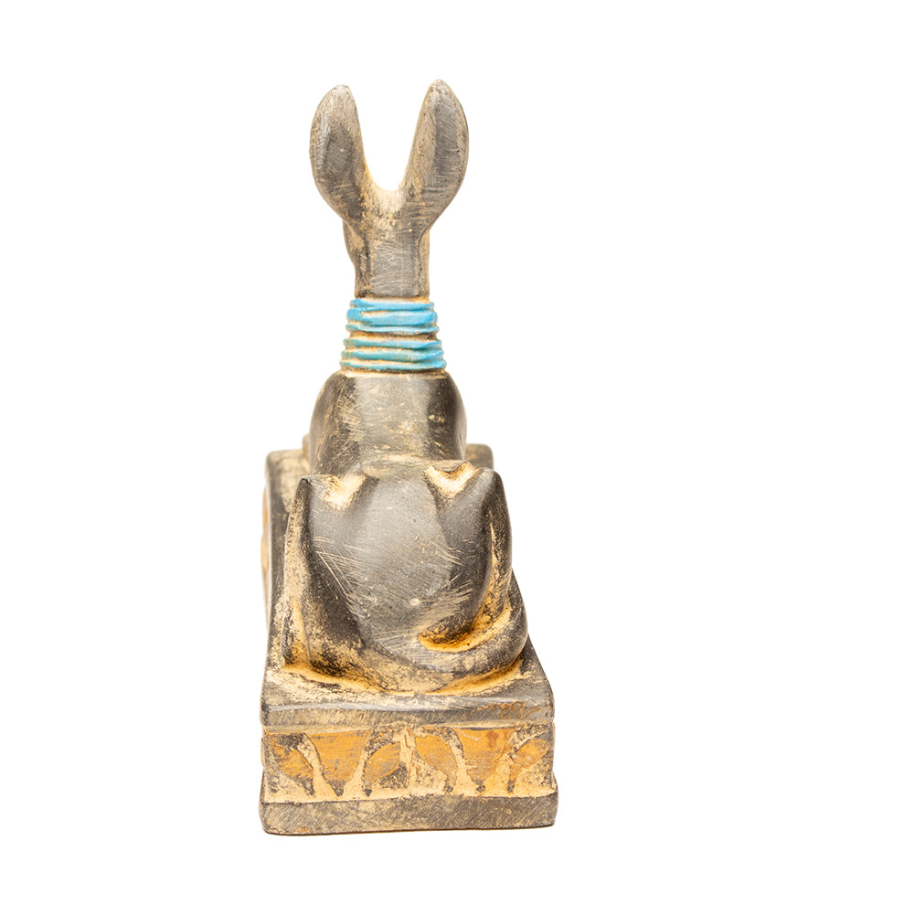 Decorative figure of a seated figure with outstretched arms on a white background