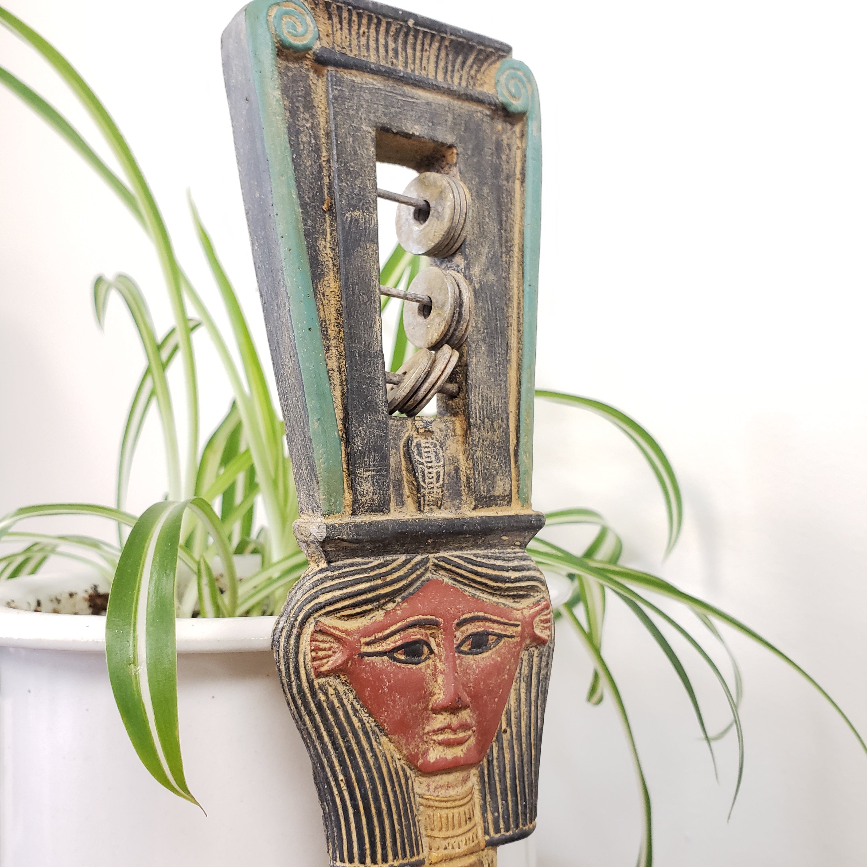 Wooden instrument with face design on a white background