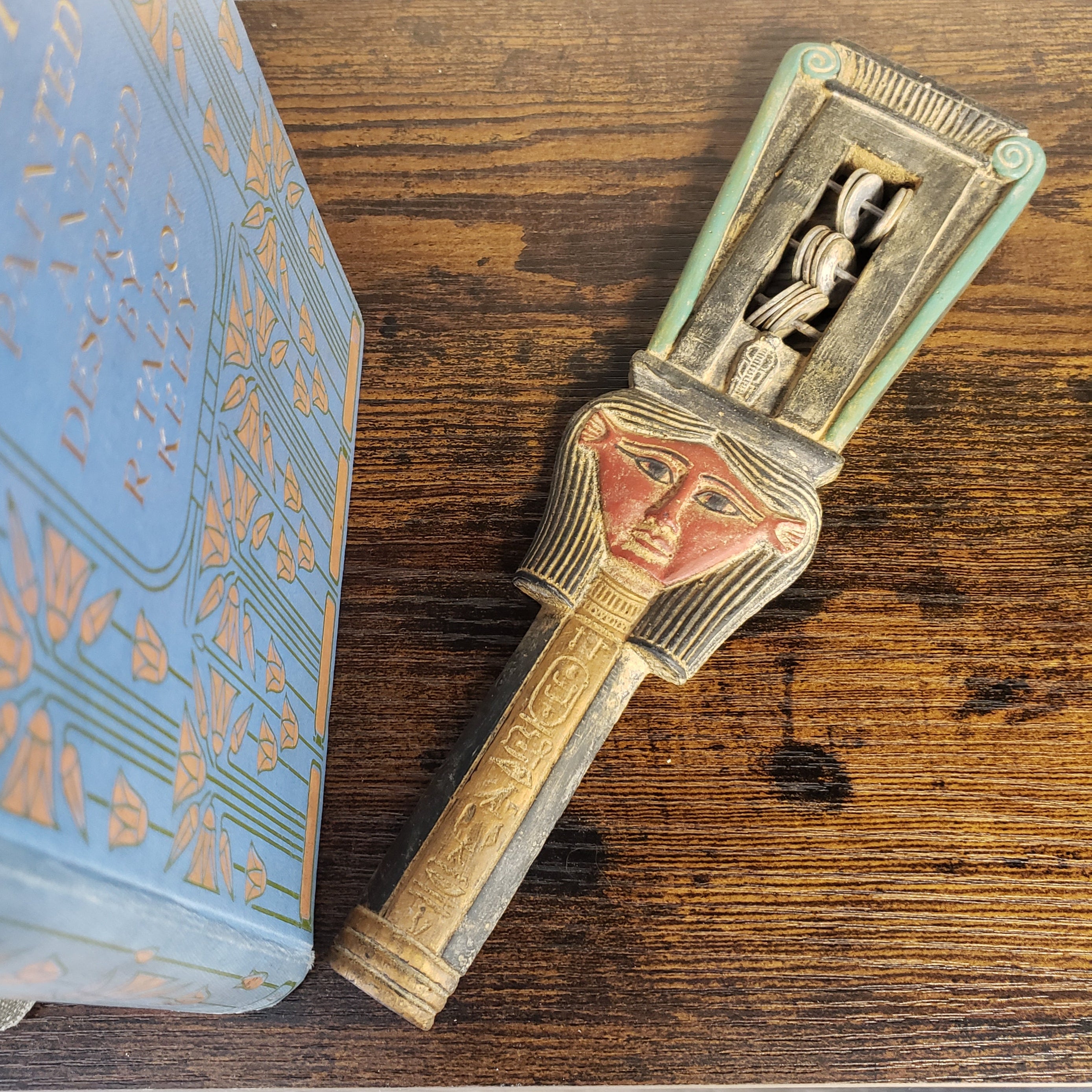Decorative key with a face design on a wooden surface
