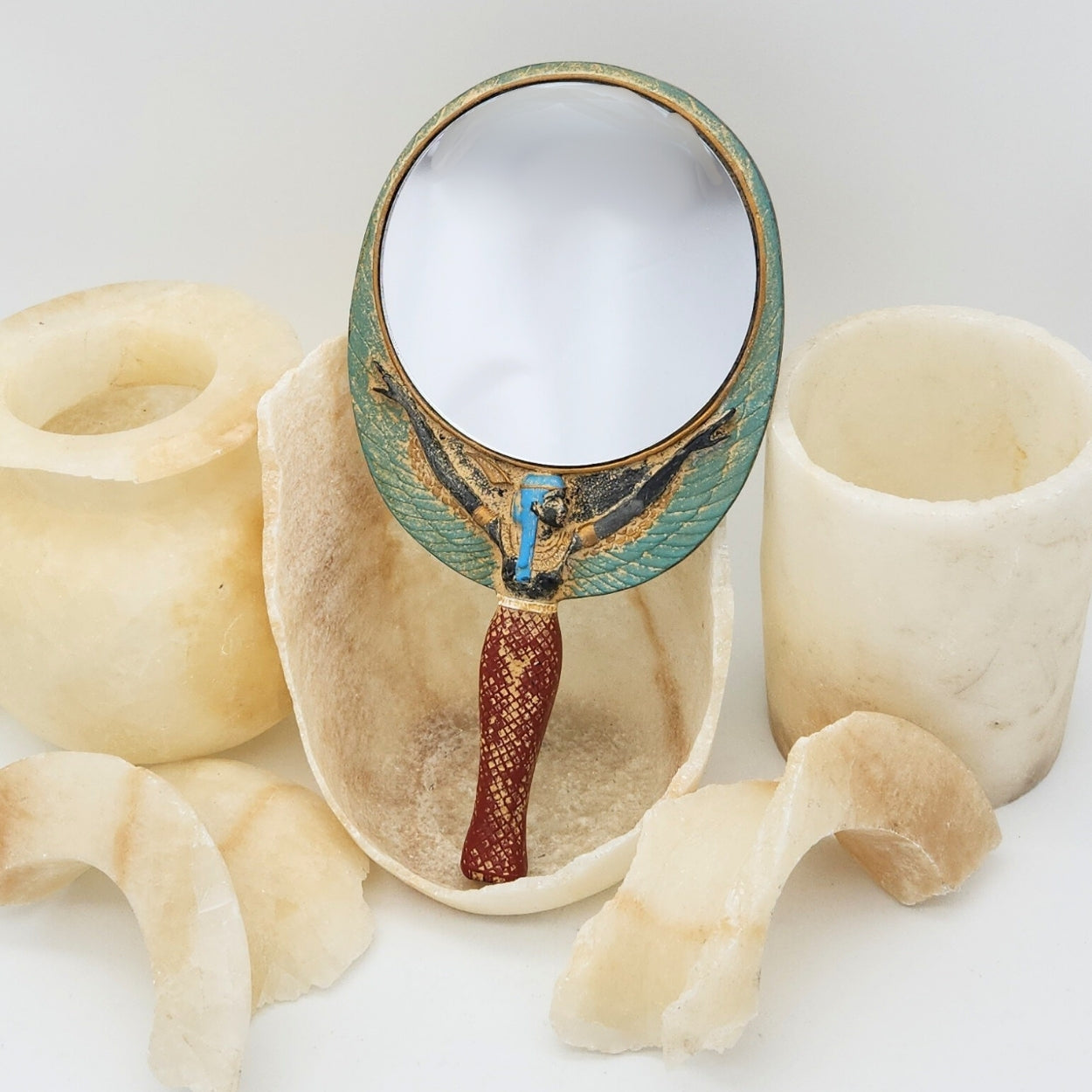 Decorative hand mirror with ancient Egyptian design on a white background
