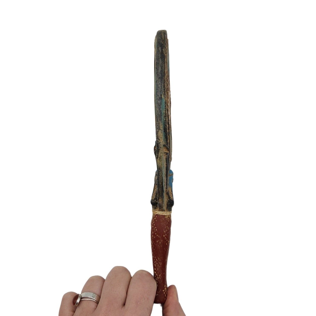 Hand holding a long, thin object with a textured surface against a white background