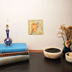 Decorative setup with books, a candle, and a small statue on a table.