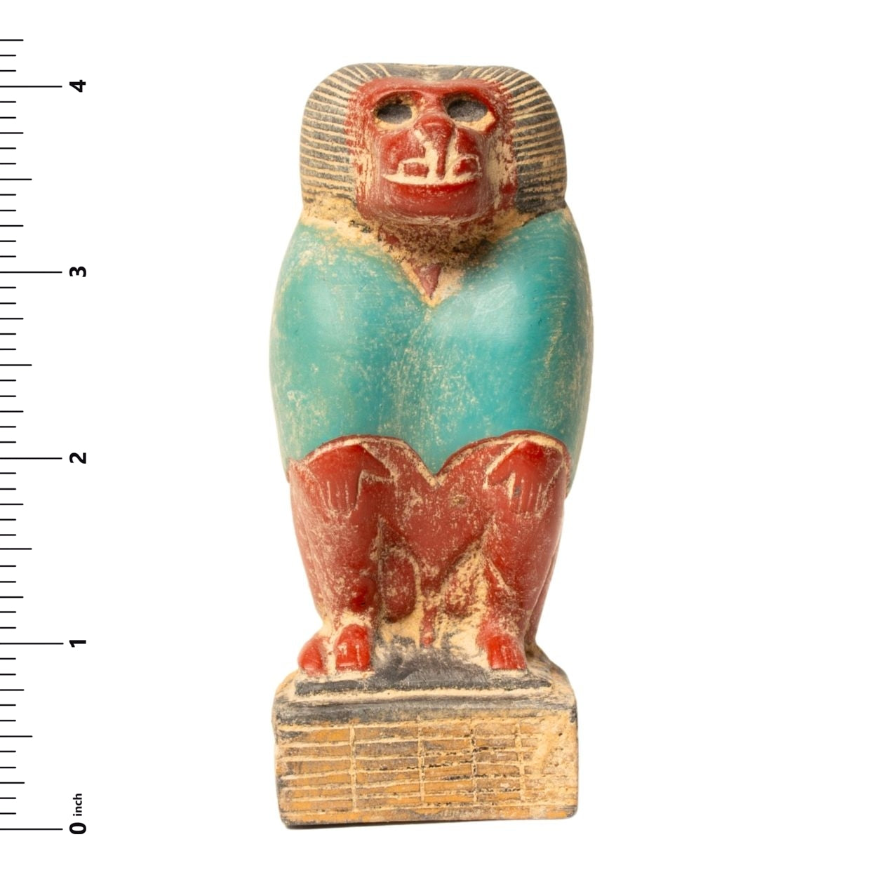 Ancient Egyptian-style figurine with a ruler for scale on a white background