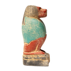 Ancient Egyptian-style sculpture with turquoise and red colors on a white background