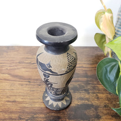 Ceramic vase with black cat design on a wooden surface